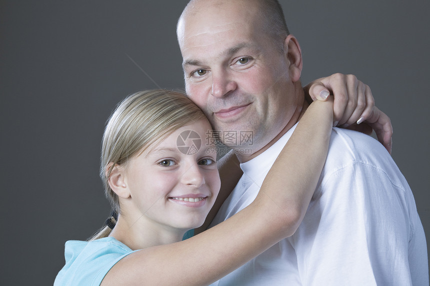 女儿拥抱父亲的摄影工作室肖像女孩家庭裁剪幸福头肩团结男子安全微笑孩子图片