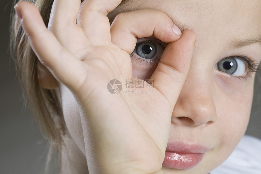 拍摄室肖像 女孩偷看 通过手的近身图片