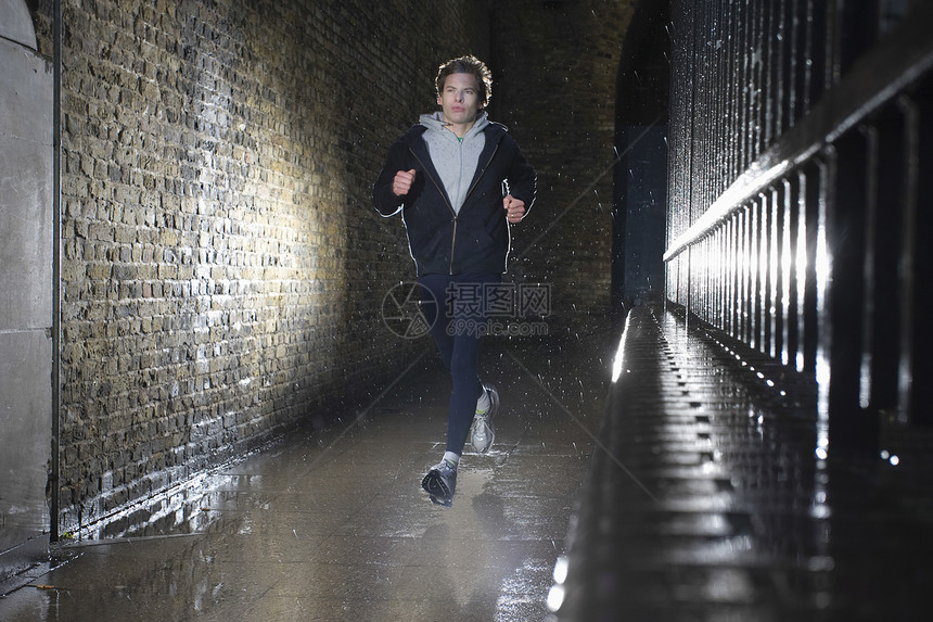 男人在夜间慢跑精神生活方式运动衫砖墙赛跑者城市隧道跑步奉献慢跑者图片