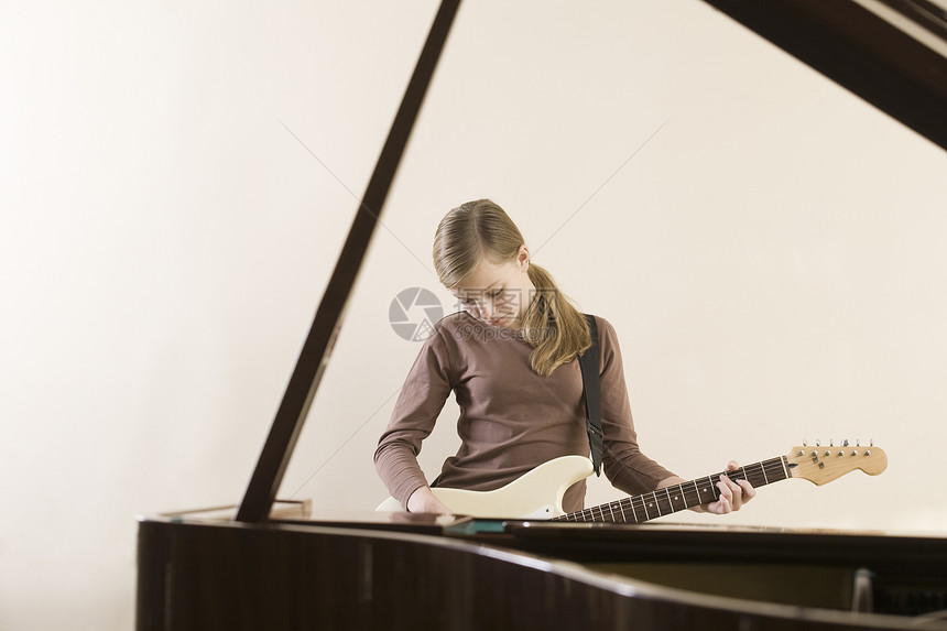 女孩1315岁弹吉他乐器学习孤独电吉他钢琴头发闲暇图片
