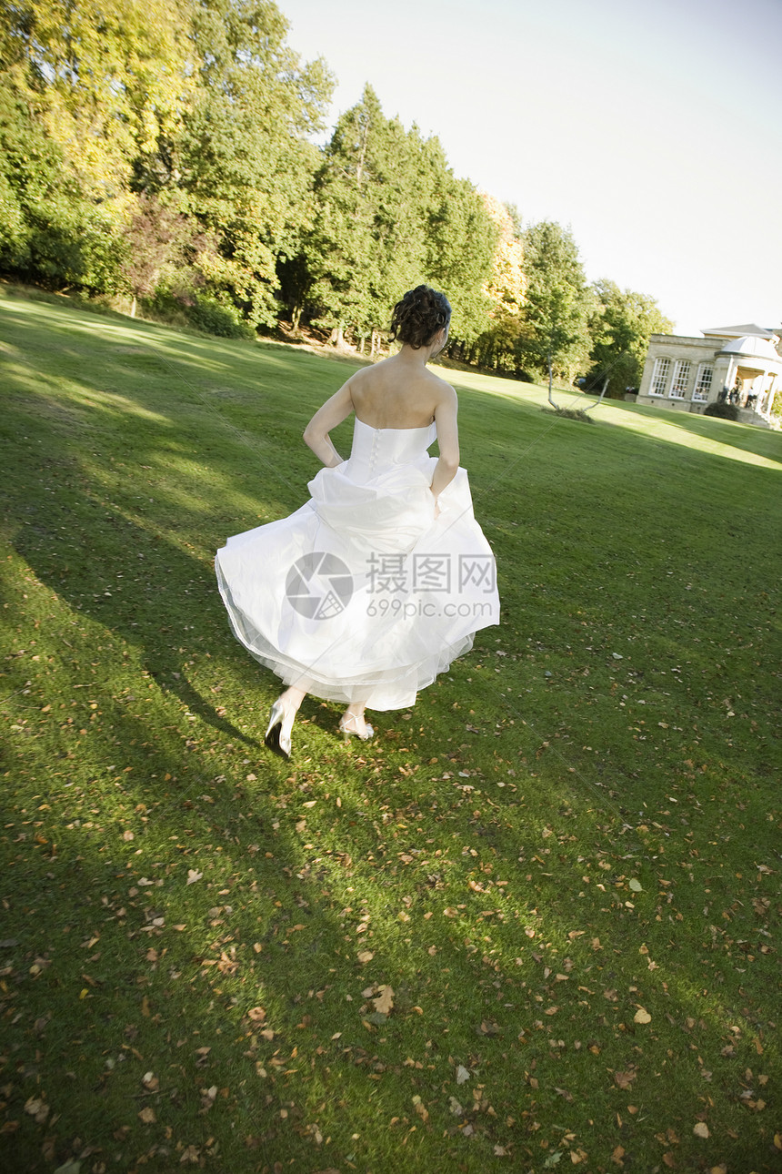 中成年新娘在公园里奔跑中年幸福婚纱人生享受女性婚礼新人大事乐趣图片