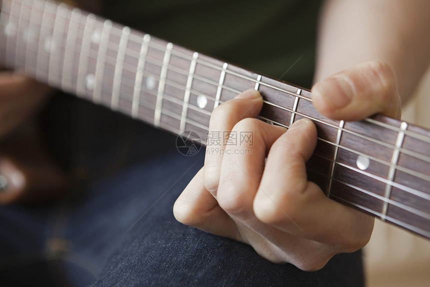 年轻人在吉他上弹奏和弦图片
