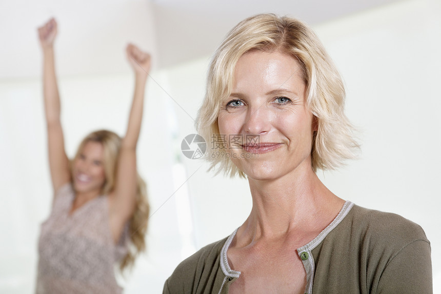 亲近母亲和兴奋的女儿举起手来图片