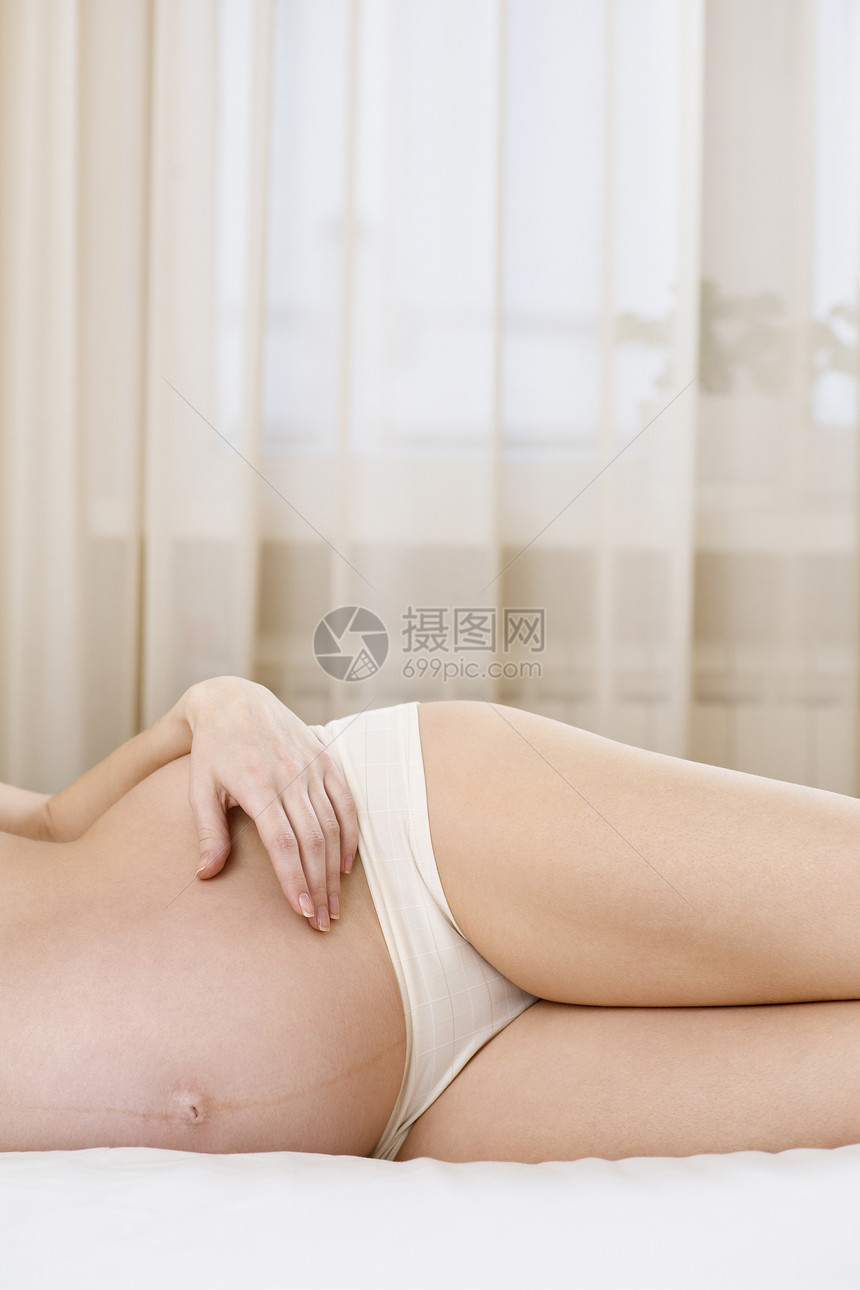 躺在床上的孕妇场景父母女性成年人怀孕生育力母亲卧室成人内衣图片