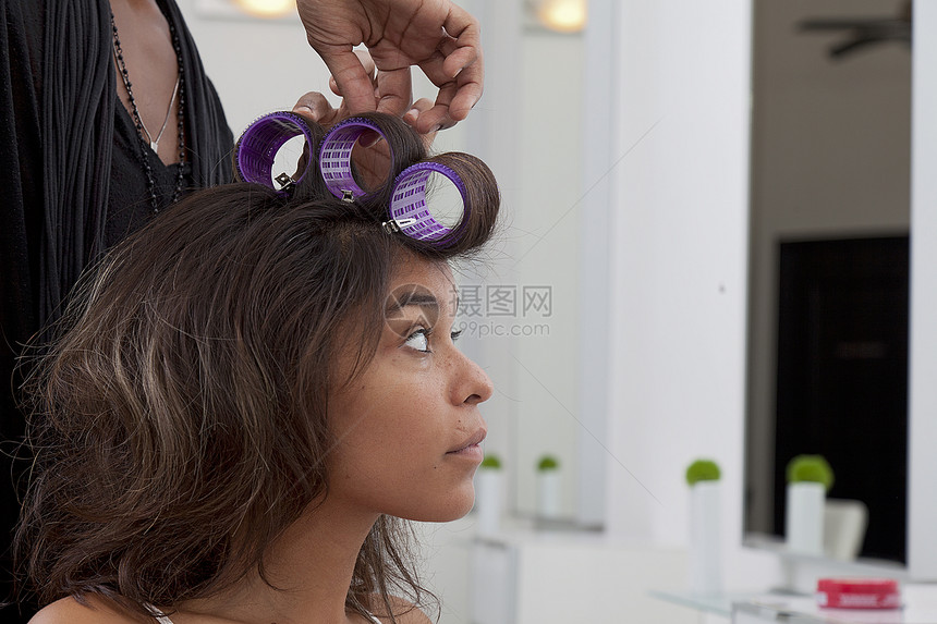 在美容院卷发的年轻女子图片
