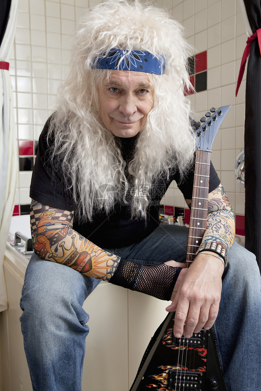 吉他手坐在浴室里的肖像图片