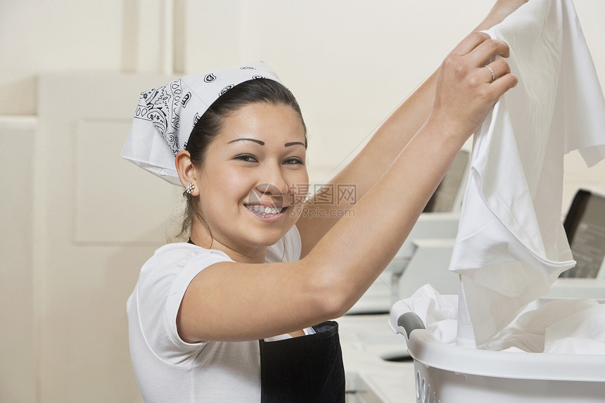 一位在洗衣店布衣的快乐年轻女子的肖像图片