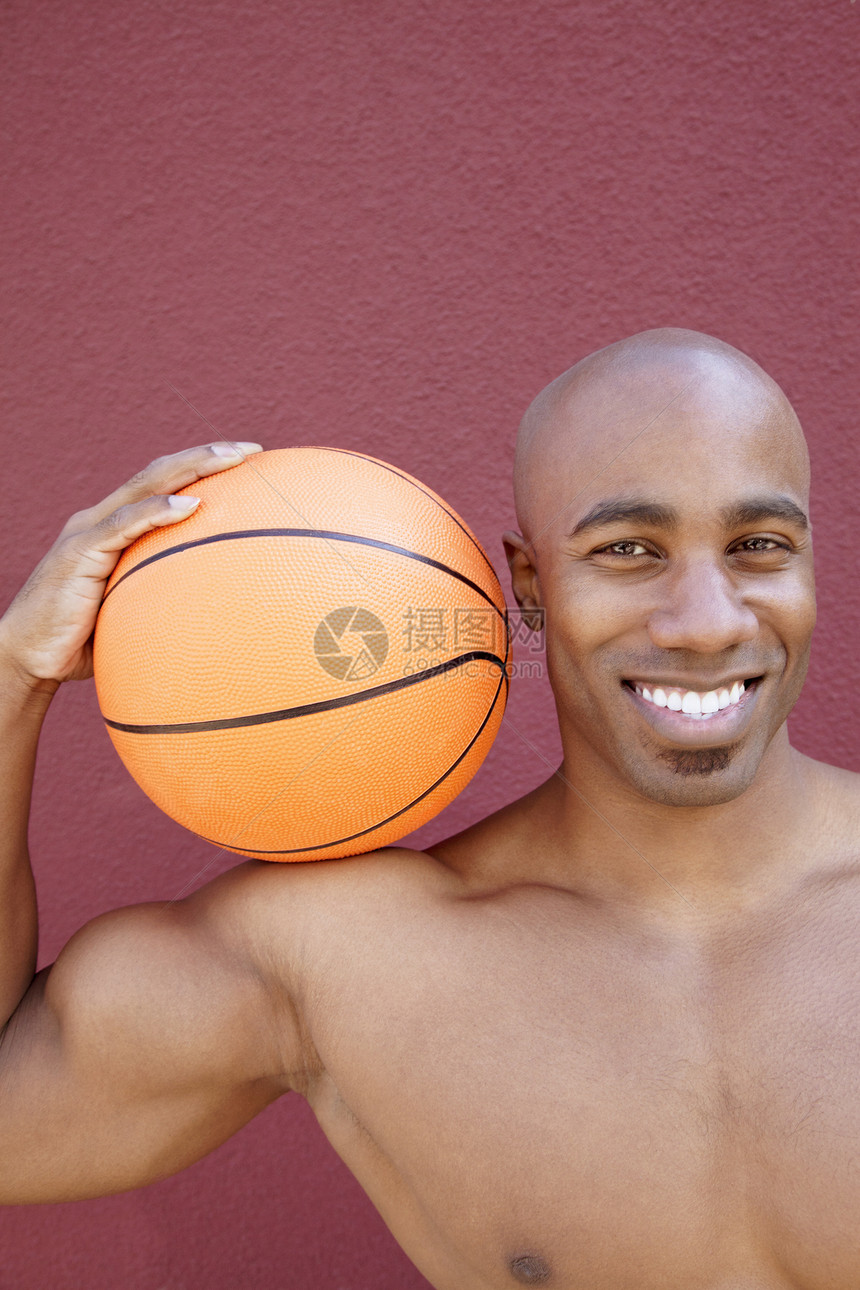 一个快乐的非裔美国人男子的肖像 篮球在彩色背景上肩并肩图片