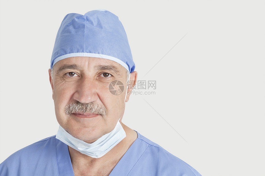 灰色背景的高级男性外科医生近视肖像图片