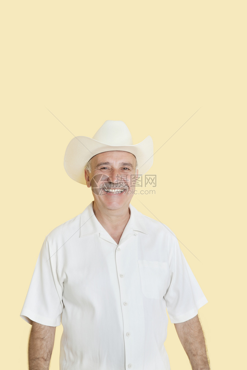 穿着黄底牛仔帽的快乐老年男子的长相肖像彩色衬衫成人男士闲暇男性影棚幸福黄色微笑图片