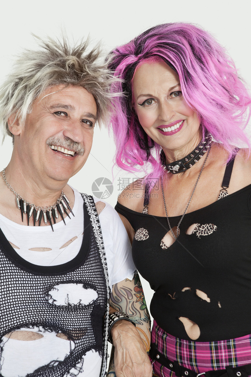 高龄朋克情侣的肖像 手举臂站在灰色背景上衣服头发男士个性男性发型项链粉色影棚女性图片