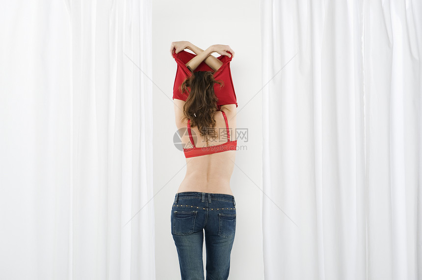 年轻女子在衣帽间脱衣服图片
