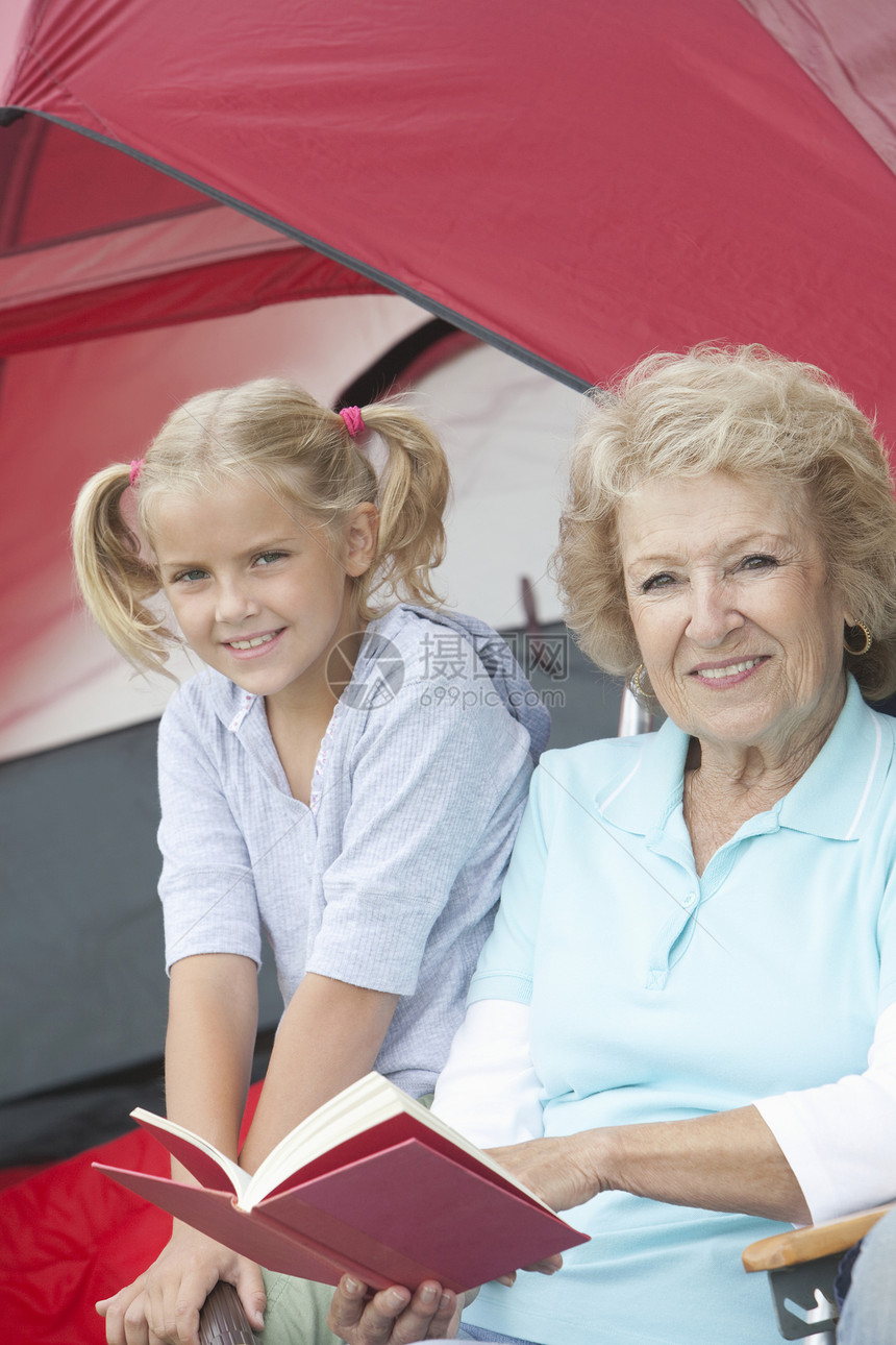 外婆和外孙女坐在帐篷外边看书 坐着看书图片