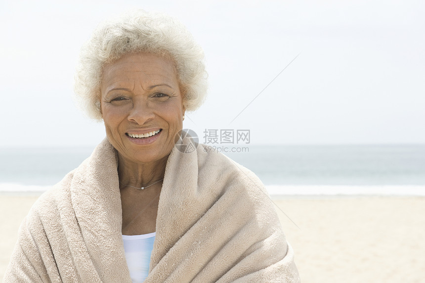 一名非洲裔美国女人的肖像 她用毛巾裹在沙滩上图片