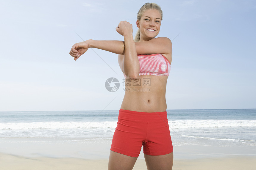 妇女在海滩上运动海洋文胸娱乐闲暇热裤微笑长发服装运动装马尾辫图片