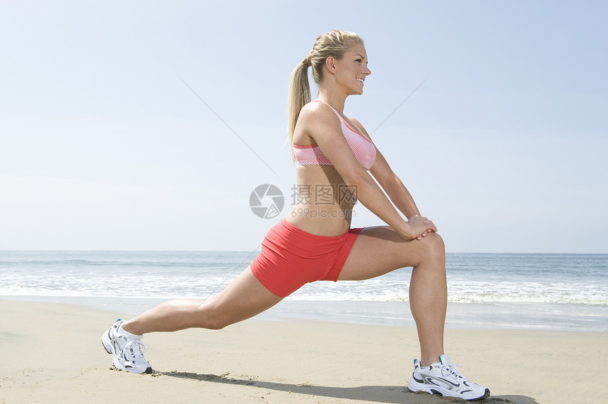 妇女在海滩上运动文胸热身女人健康马尾辫锻炼长发娱乐拉伸热裤图片