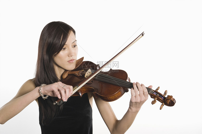 玩小提琴的年轻女子与白种背景隔绝图片