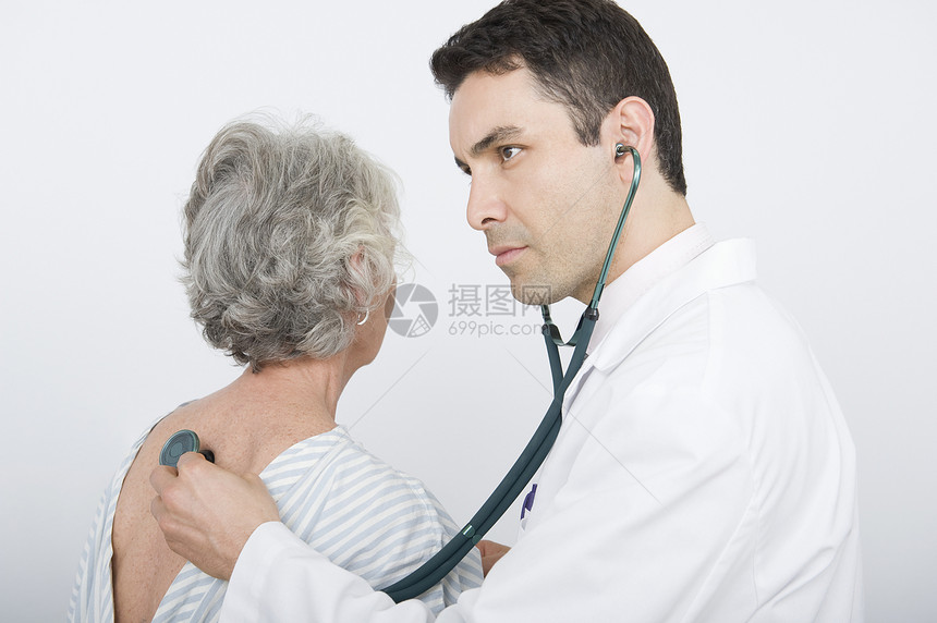 中年成人医生检查高级病人的呼吸体格男人男性器材专注男子两个人女性大衣从业者图片