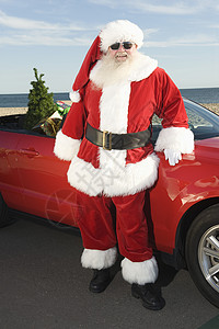圣诞老人车圣诞之父站在红敞篷车和圣诞树旁边胡须运输位置颜色衣服夹克老年太阳镜胡子舞会背景