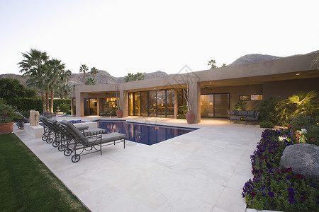 游泳池周围的阳光 对抗现代房子和清空天空背景图片