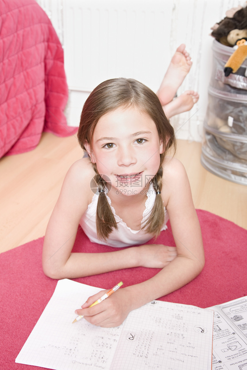 做家庭作业的年轻女孩微笑服装孩子一个女孩尾巴粉色棕色赤脚脚踝长发图片