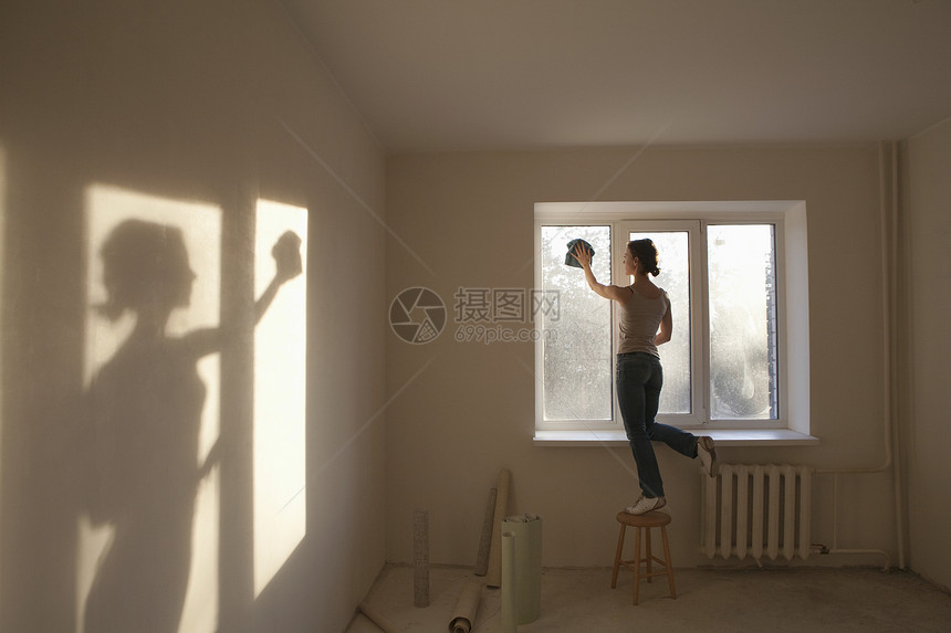 妇女在新公寓中打扫窗户图片