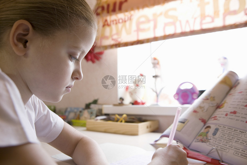 10岁女孩坐在窗口桌前做功课图片