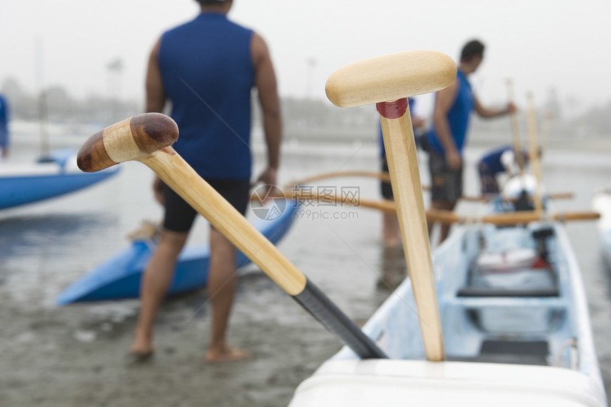 海上单艇赛队准备他们的船海滩男士运动外表独木舟运动员混血前景赤脚图片