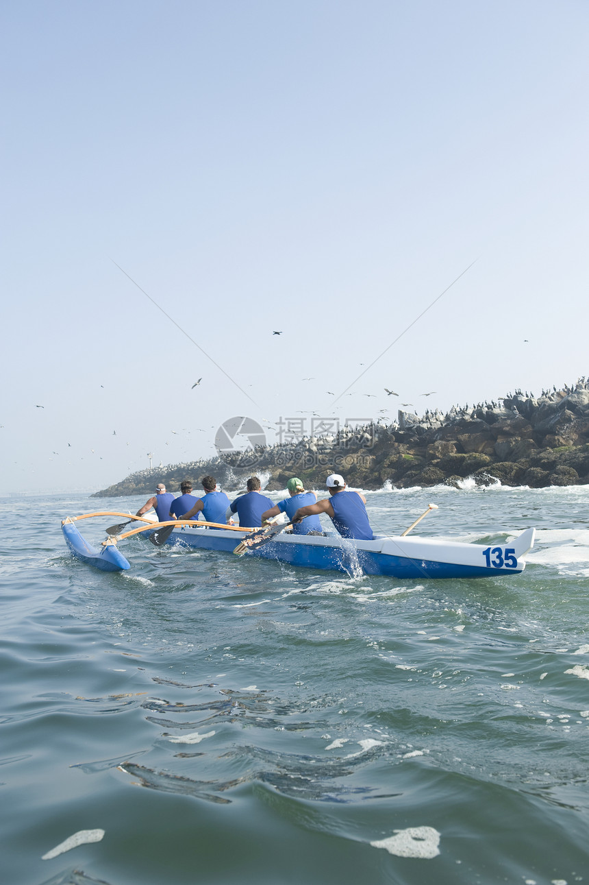 训练中的越野独木舟小组赛车运动蓝色蓝天天空海洋岬角飞溅竞赛运动员图片
