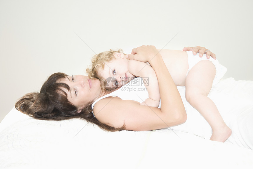 一个母亲躺下 抱着一个幼儿躺在她身上图片