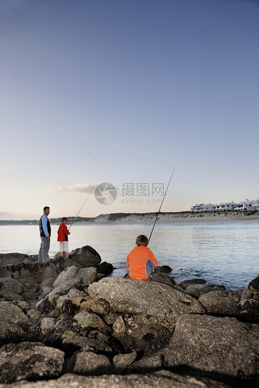 父亲和两日太阳在南非兰盖班天堂海滩捕鱼 南非海洋天堂钓竿岬角橙色天空三个人儿子孩子们孩子图片