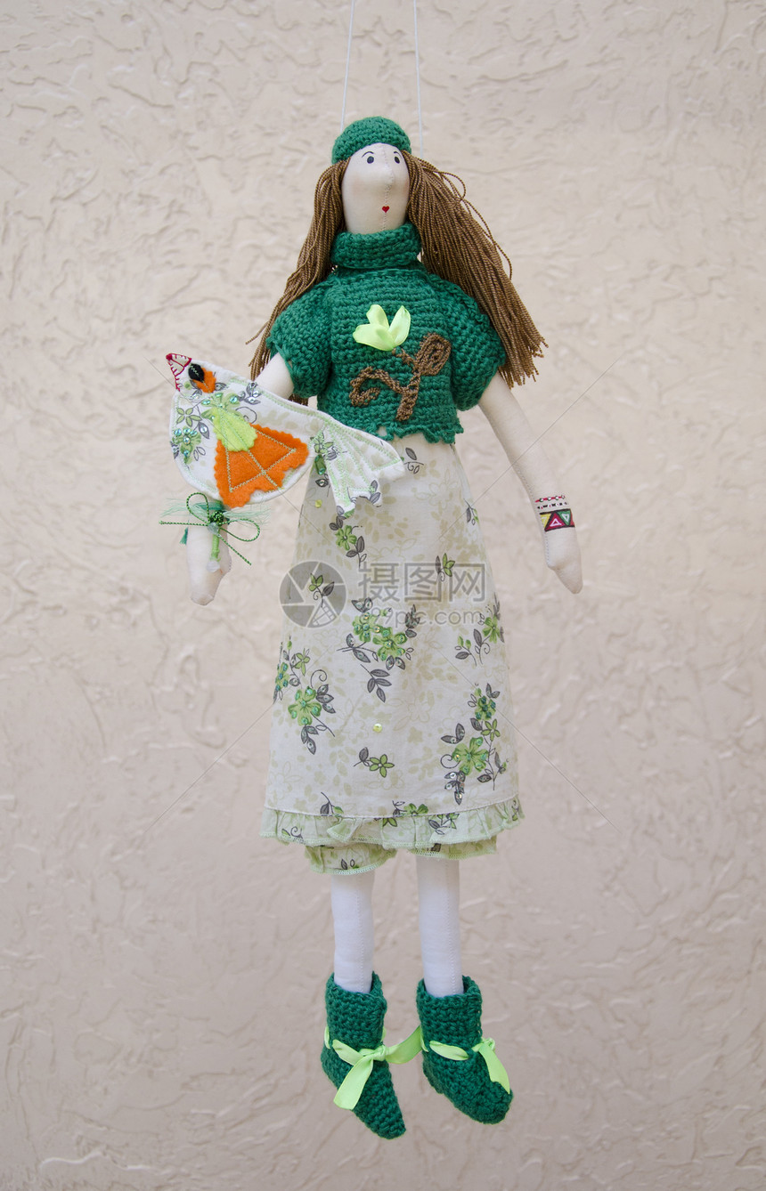 手工制作的娃娃 手头上有一只鸟 穿着衣服和毛衣图片