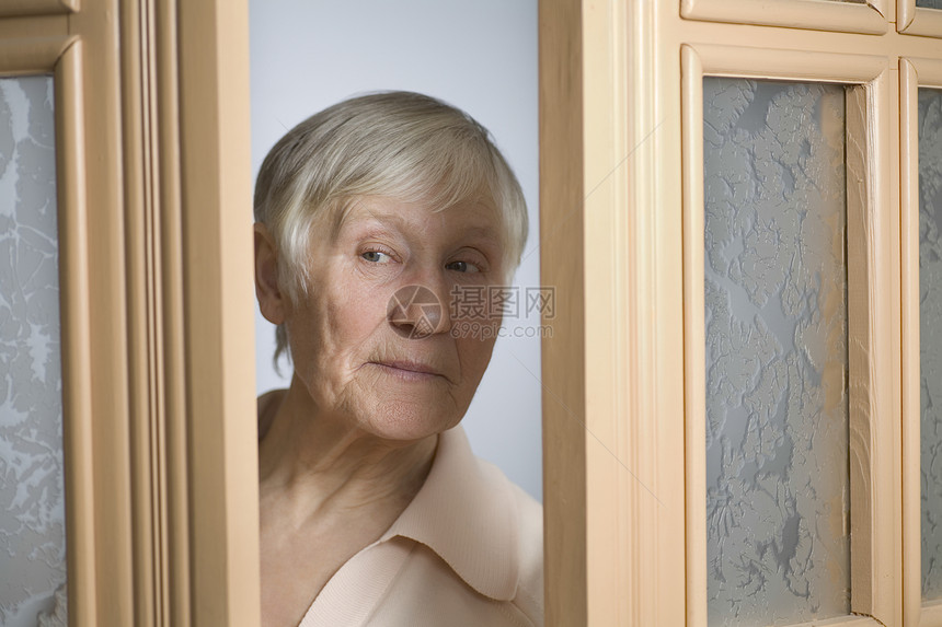 白头发短发的老年妇女打开前门;图片