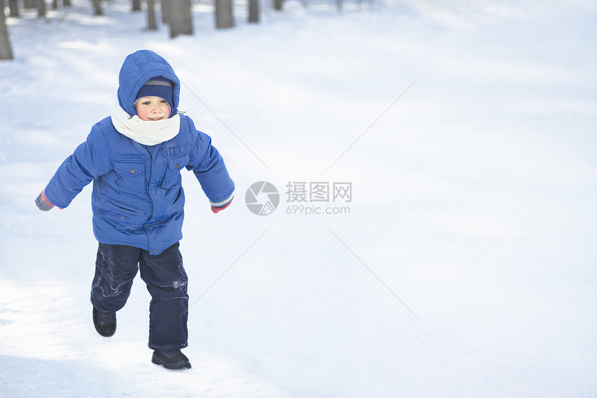 年青男孩在雪中奔跑图片