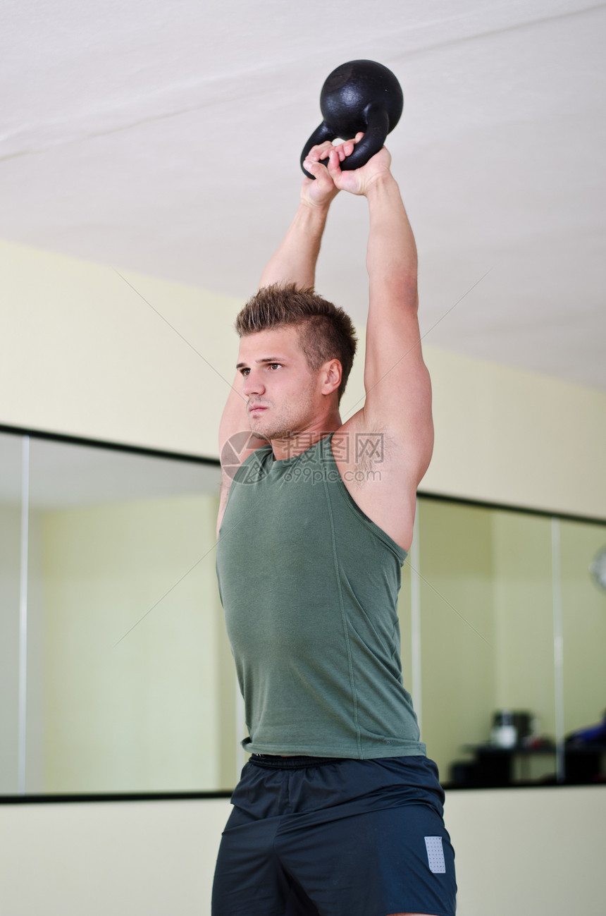 英俊的年轻男子 在健身房工作与水壶铃白色训练权重运动讲师肌肉举重男性健美重量图片