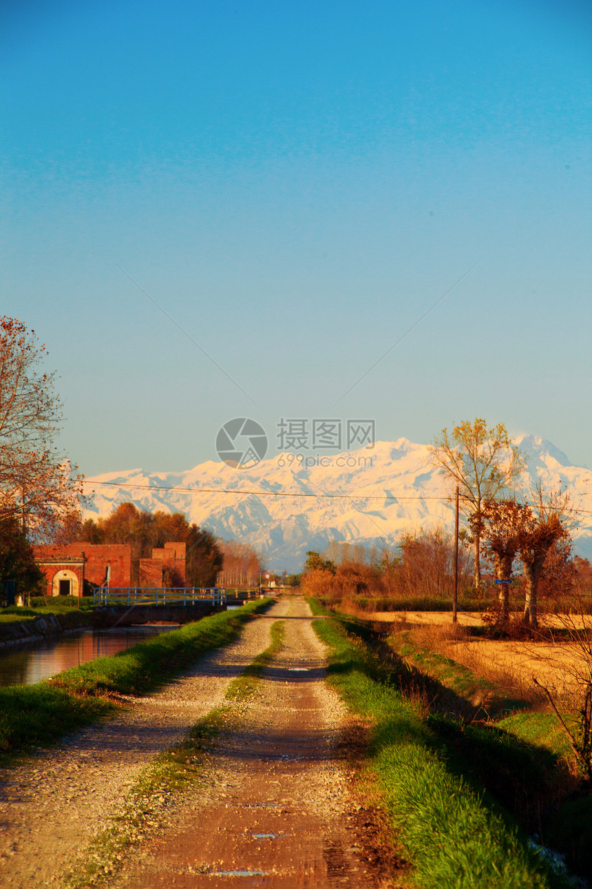 通往山区的道路旅行蓝色土地晴天沥青太阳草地绿色缠绕地平线图片