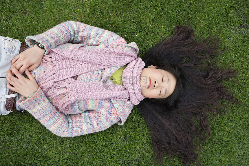 坐在草坪上长着黑头发的亚洲年轻女性最美景图片