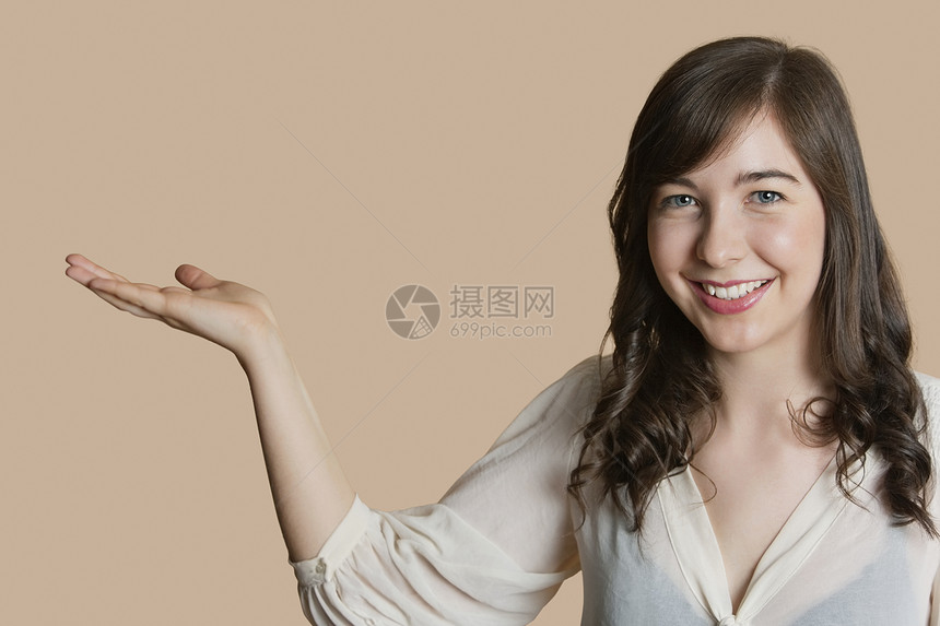 一个快乐的年轻女人的肖像 空手过彩色背景图片