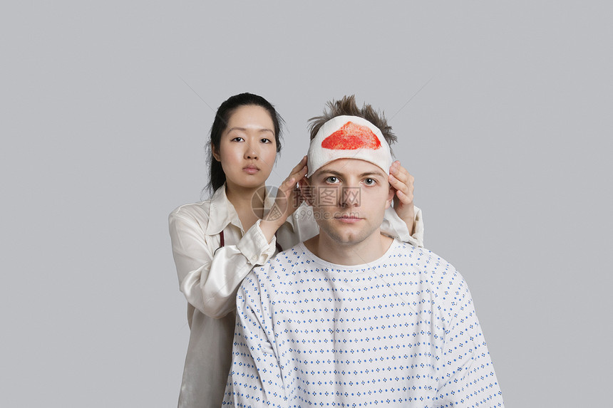 女性医生检查受伤男性病人的外科手术图片