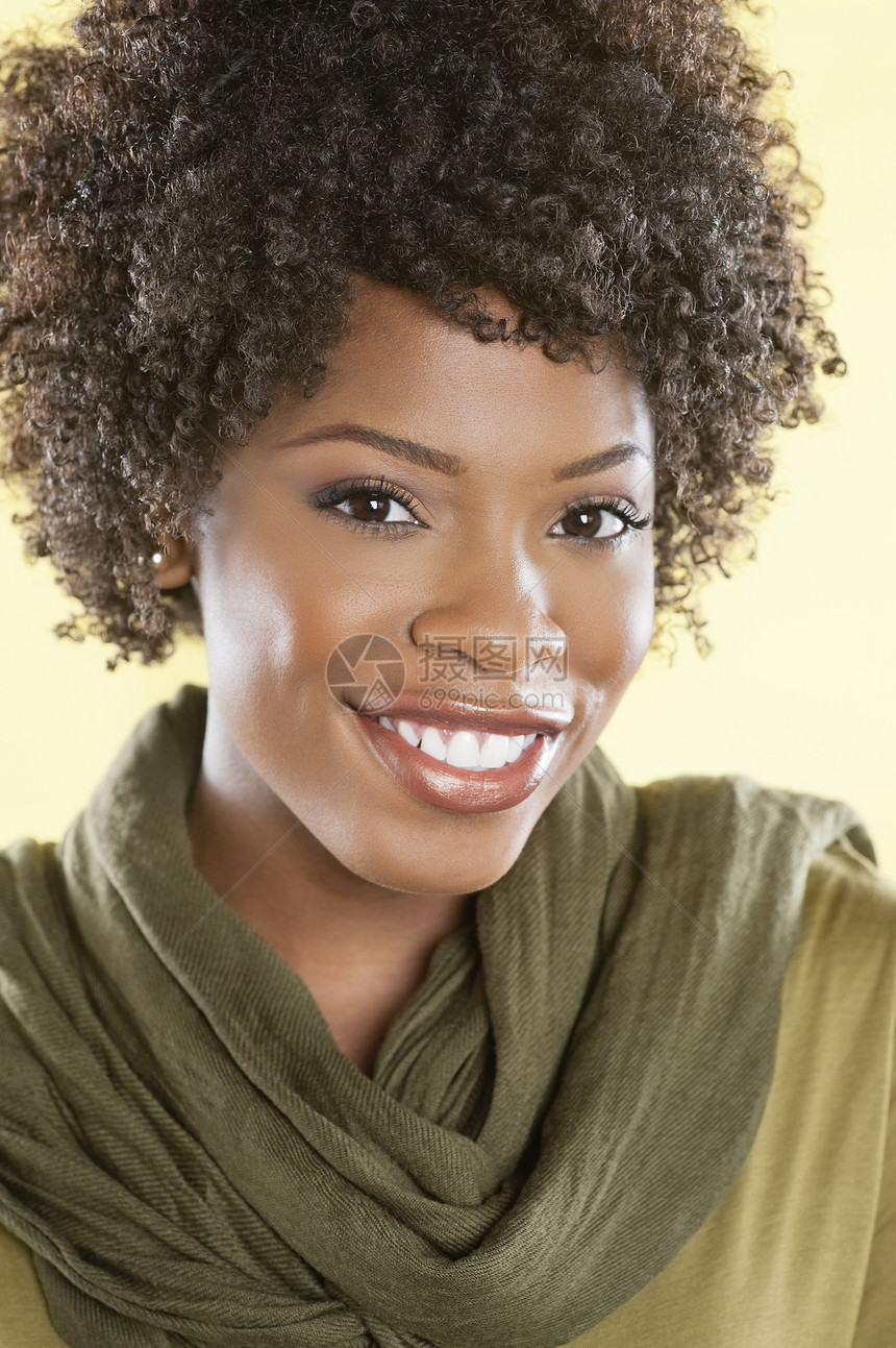 一名非裔美国人妇女被蒙着彩色背景的衣物 在脖子上围着一个被偷走的颈部微笑而微笑的肖像服装成人成年短发种族头肩休闲女性幸福卷发图片