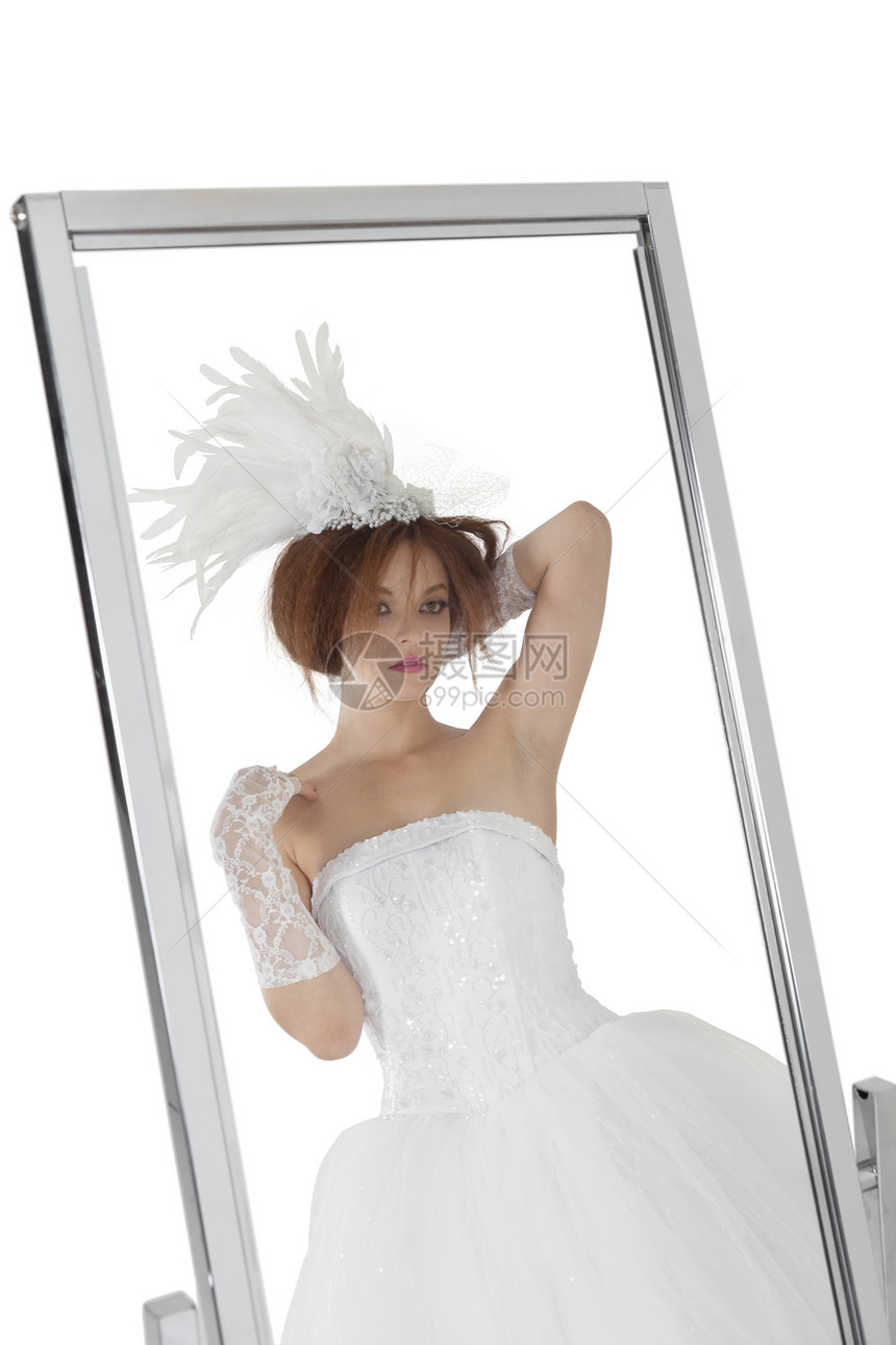 年轻新娘在白色背景的镜子中反射出来图片