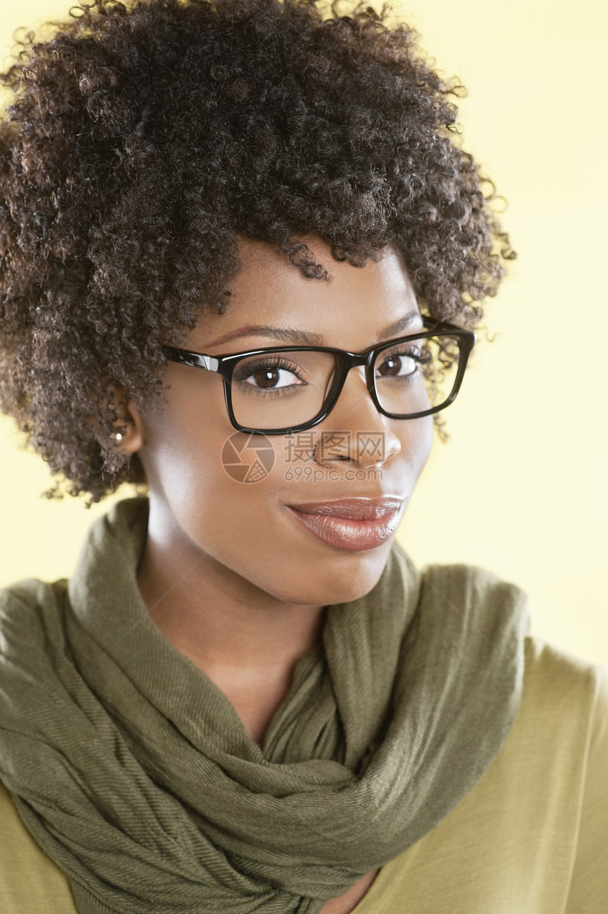 一名非洲裔美国妇女身戴眼镜 脖子上围着一个被偷走的手环在彩色背景上偷来的眼镜的肖像图片