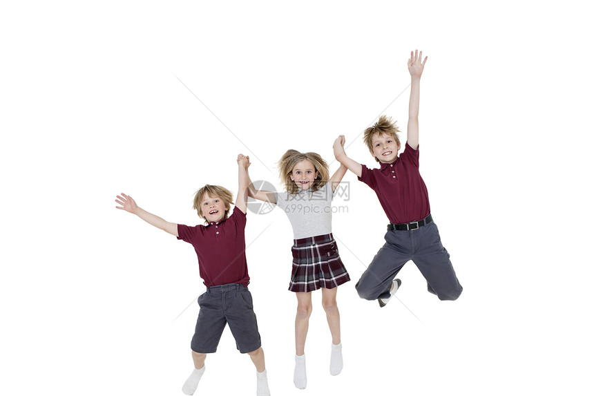 快乐的学校儿童在跳过白背景时手牵手的肖像图片