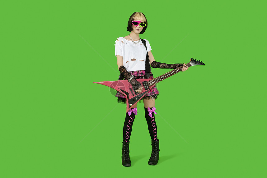 配有吉他和绿色彩色背景的朋克女人图片