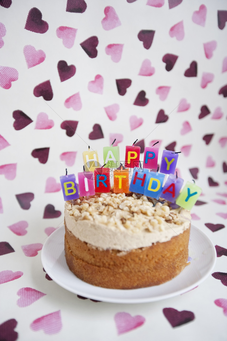特写生日蛋糕 在心形背景上用蜡烛做蜡烛图片