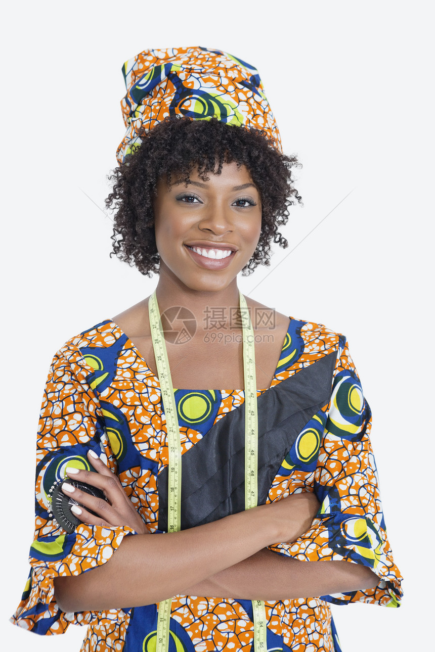 身穿非洲印刷服装的年轻女时装设计师的肖像 手靠灰色背景折叠图片