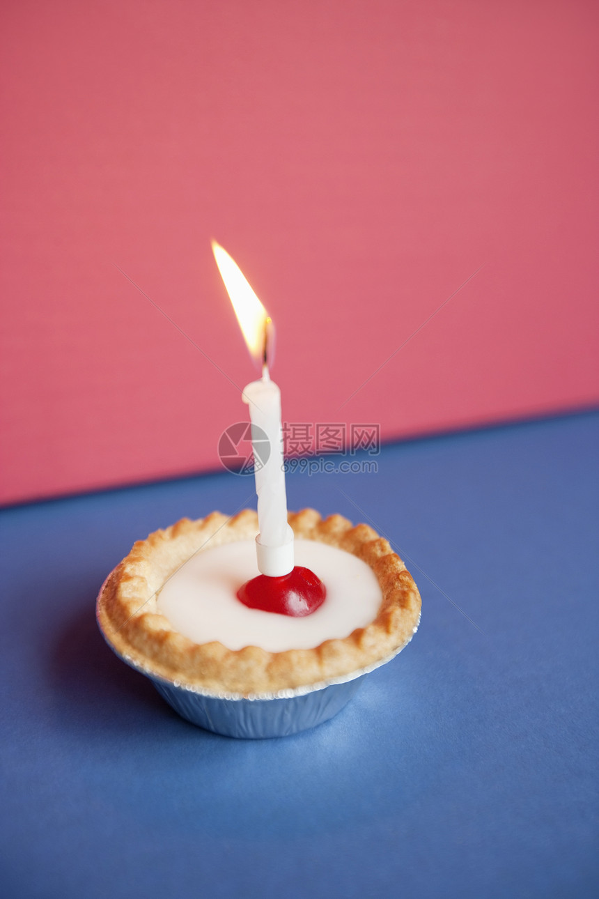以彩色背景在纸杯蛋糕上烧蜡烛图片