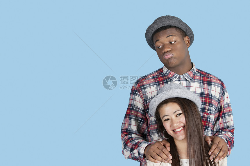带着蓝背景笑笑的女友的非洲黑人男子 在蓝背景下图片