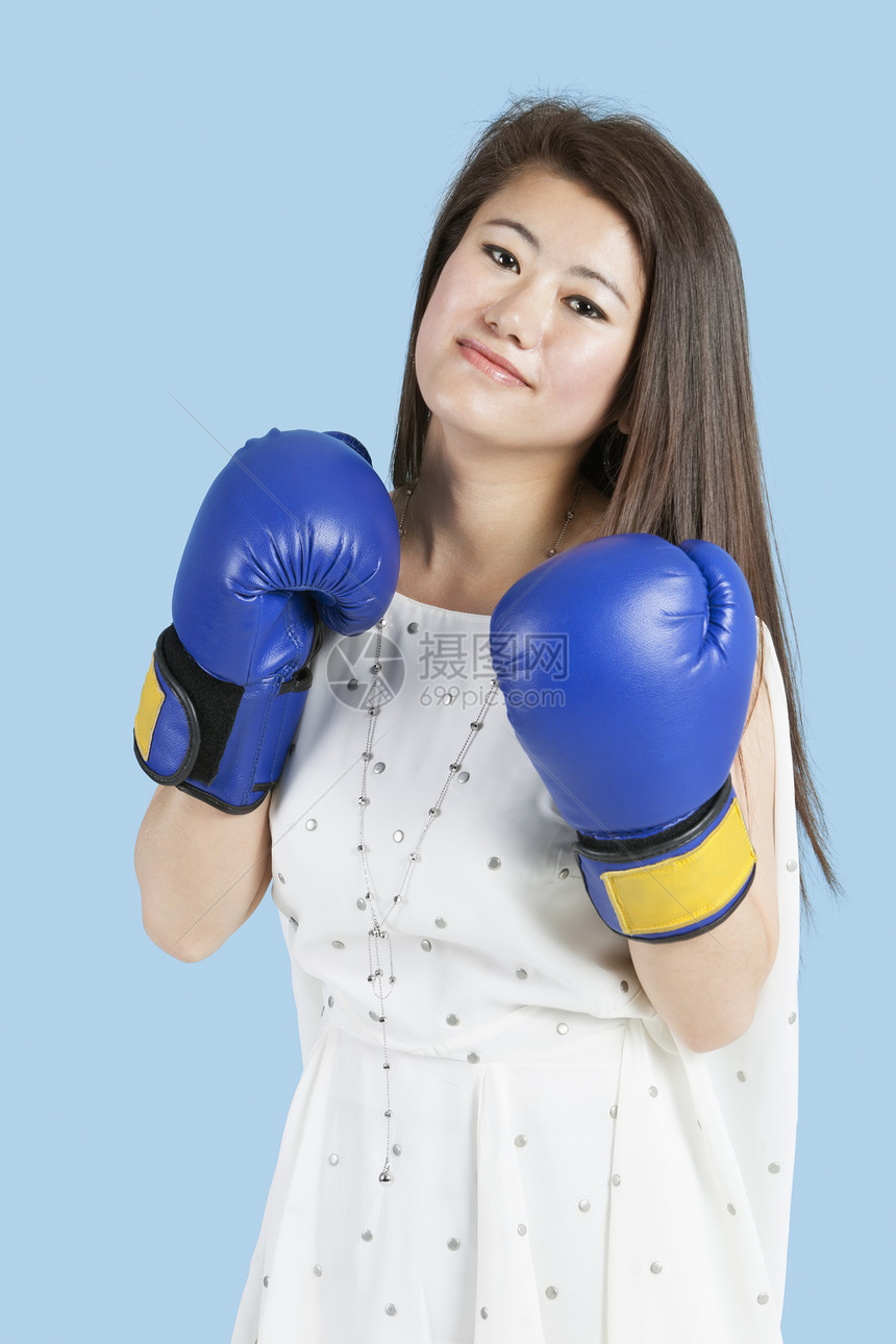 一名身穿蓝底拳击手套的年轻美女的肖像图片