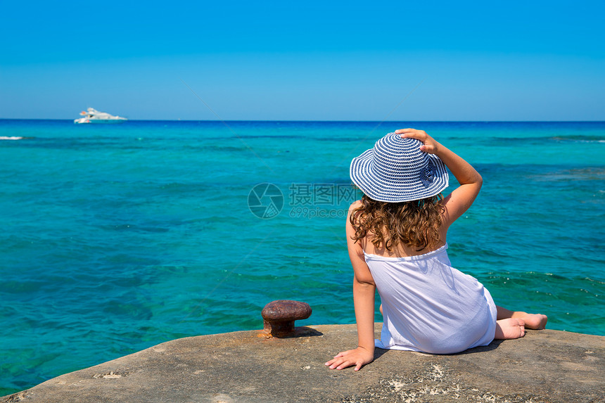 女孩在Formentera绿绿石地中海的海滩观望旅行蓝色地平线女性孩子童年帽子女士太阳闲暇图片